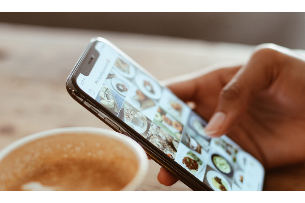 Person on phone looking at Instagram with a coffee