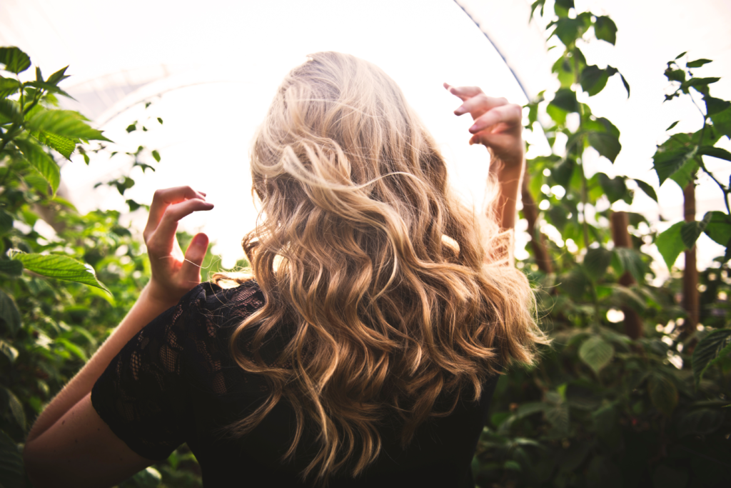 Woman with blonde hair near trees